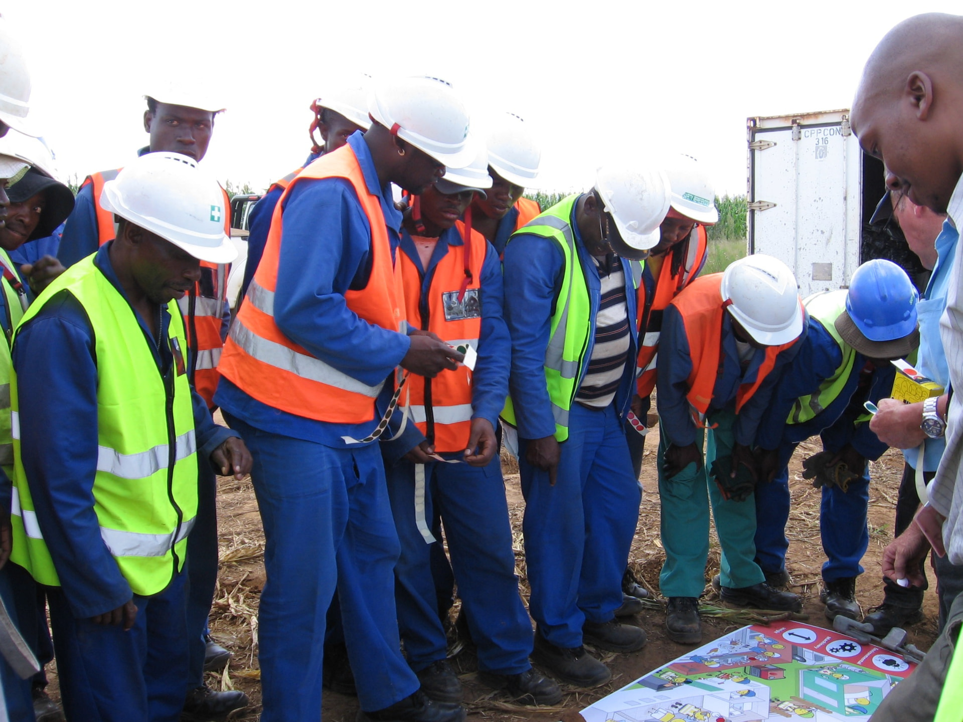 New Ice City site crew in PPE gathered around a safety plan during a toolbox briefing